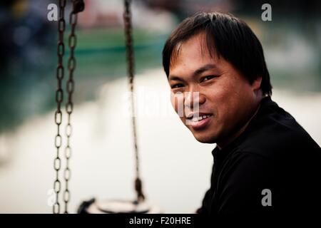 Ritratto di uomo anziano, vista laterale guardando sopra la spalla alla fotocamera a sorridere Foto Stock