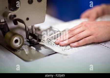 Le mani dei maschi di designer tessile mediante cucitura a macchina nel vecchio mulino tessile Foto Stock