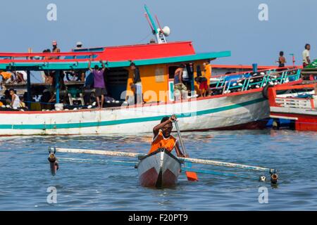 Indonesia, Maluku provincia, Est Seram, isola di Gorom, ragazzo pagaiando su una barca tradizionale Foto Stock