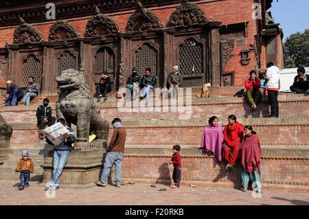 Il Nepal, valle di Kathmandu, Kathmandu, il quadrato di Durbar elencati come patrimonio mondiale dall' UNESCO, persone sedute al mattino sole invernale a Durbar Square (archivi) Foto Stock