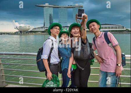 Singapore, Marina Bay, Marina Bay Sands luxuary hotel aperto nel 2010 e delle arti e delle scienze museo con il suo fiore di loto forma costruito dall'architetto Moshe Safdie, turisti fotografare dal Parco Merlion Foto Stock