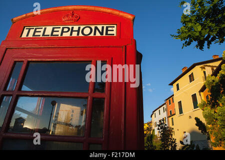 L'Italia, Toscana, Lucca, Barga, British telefono box con facciate delle vecchie case di città in background. Foto Stock