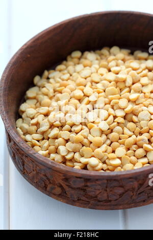 Le lenticchie in una ciotola di legno su legno bianco Foto Stock