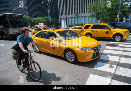 I taxi di condividere la strada con la bici e altro traffico a New York il giovedì, 3 settembre 2015. A causa dell'aumento Uber e altre app taxi medaglioni sono diminuiti in che vale la pena di circa $900.000 con prestito insolvenze in aumento. Il Melrose Credit Union è $168 milioni in insolvenze come di Maggio 2015 mentre nel gennaio 2014 aveva solo $32.000. Nei prossimi sei mesi Melrose è $212 milioni di euro in prestiti in scadenza che molti proprietari non sarà in grado di pagare. (© Richard B. Levine) Foto Stock