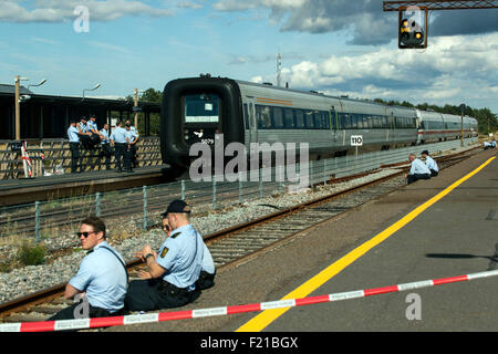 Roedby, Danimarca, Settembre 9th, 2015. La polizia circonda i due treni del porto di Roedby con alcuni 240 rifugiati che vuole chiedere asilo in Svezia. È loro negato il transito attraverso la Danimarca e la polizia li richiedono fuori dei treni. La strategia di polizia è stato il dialogo e non con la forza. Credito: OJPHOTOS/Alamy Live News Foto Stock