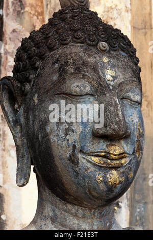 Thailandia, Sukothai, Close-up di tempo-annerito del Buddha volto, con i resti di blu e oro dipingere, Wat Saphan Hin. Foto Stock