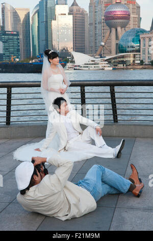 Fotografo giace a terra per catturare la sposa e lo sposo al Bund, Shanghai, Cina e Asia Foto Stock