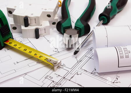 Accessori per lavoro, fusibile elettrico e rotoli di schemi elettrici su disegno di costruzione della casa, utensile di lavoro Foto Stock