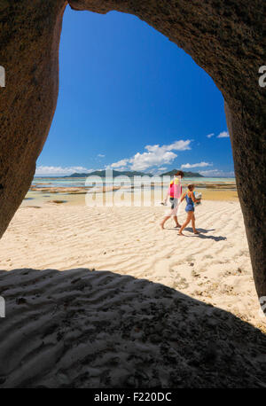 I turisti a camminare sulla spiaggia di sabbia, isola di La Digue e le Seicelle. Foto Stock