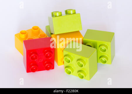 Lego mattoni di edificio in diversi colori su sfondo bianco. Foto Stock