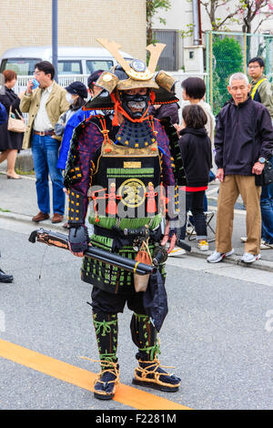 Tada Genji sfilata in Giappone. Samurai, in rinascita armature e la maschera per il viso, uomini yoroi, del periodo Edo con Hinawa-jyuu, matchlock pistola, marching. Foto Stock