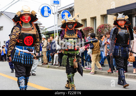 Tada Genji sfilata in Giappone. Tre Samurai, in rinascita armature e la maschera per il viso, uomini yoroi, del periodo Edo con Hinawa-jyuu, matchlock pistola, marching. Foto Stock