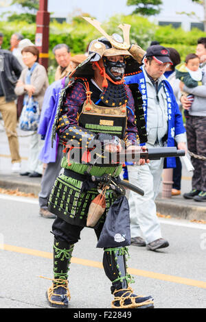 Tada Genji sfilata in Giappone. Samurai, in rinascita armature e la maschera per il viso, uomini yoroi, del periodo Edo con Hinawa-jyuu, matchlock pistola, marching. Foto Stock