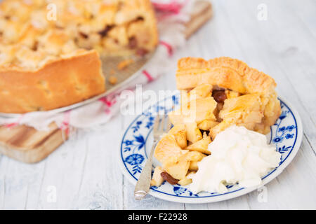 In casa olandese torta di mele con panna montata su un tavolo rustico. Foto Stock