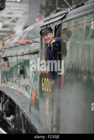 Treno a vapore conducente guardando fuori la sua cabina. Foto Stock