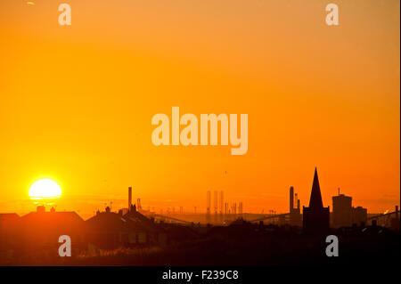 Set di sole sopra Redcar SSI industria acciaierie silouetted contro un bagliore arancione Foto Stock