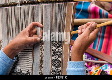 Il Perù, regione di Cusco, Donna tessitura con telaio tradizionale al di fuori del negozio di articoli da regalo a Ccochahuasi Santuario degli animali nella Valle Sacra Foto Stock