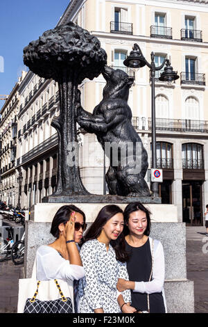 Madrid Spagna,Centro ispanico,Plaza de la Puerta del Sol,piazza centrale,El Oso y El Madrono,Orso e Strawberry Tree,statua,simbolo,emblema,donna asiatica fem Foto Stock