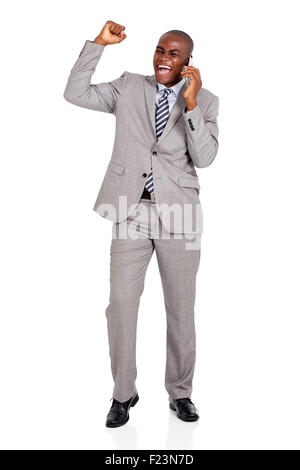 Eccitato giovane africano business man parlando al cellulare Foto Stock