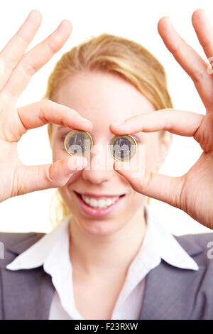 Donna Felice Tiene due monete in euro di fronte ai suoi occhi Foto Stock
