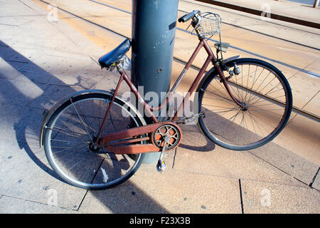 Vecchia bicicletta abbandonato sul polo di ferro Foto Stock