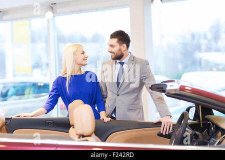 Coppia felice l'acquisto di auto in auto show o salon Foto Stock