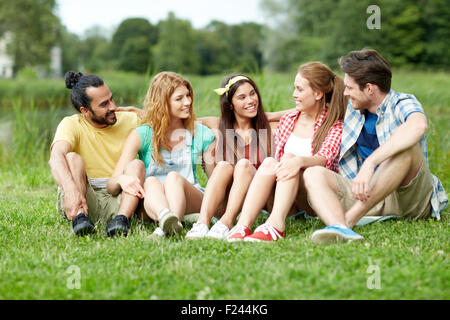 Gruppo di amici sorridente parlando all'aperto Foto Stock