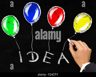 Uomo a scrivere la parola "Idea" con palloncini ad esso collegato con un gessetto sulla lavagna sfondo Foto Stock