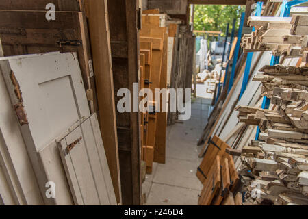 Vari oggetti in legno (per lo più porte e la scala di fusi) sul display in un architectural salvage yard in Inghilterra meridionale, Regno Unito. Foto Stock