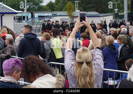 Gli spettatori della stazione Tweedbank attesa per la regina ad aprire ufficialmente i nuovi confini della linea ferroviaria - pipe band suonare Foto Stock