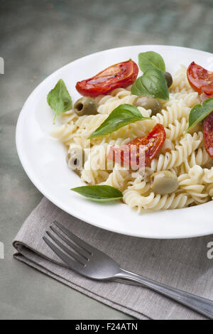 Pasta con pomodori al forno e olive verdi Foto Stock