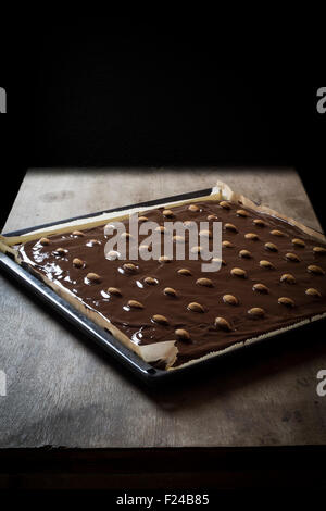 Vassoio di pan di zenzero di fresco con sparse fuori di cioccolato e le mandorle sulla tavola di legno top Foto Stock