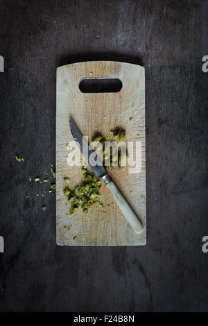 Intero e pistacchi tritati con coltello vintage rustico di legno sul tavolo di legno alto. Vista superiore Foto Stock