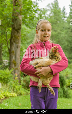 Di undici anni ragazza con il suo Buff Brahma hen in Issaquah, Washington, Stati Uniti d'America Foto Stock