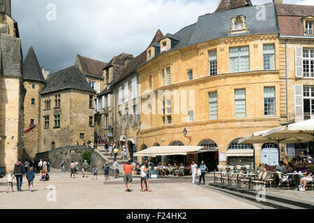 Turisti che si godono la Place de la Liberte a Sarlat Francia in thundery meteo Foto Stock