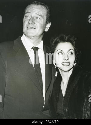 JOHN WAYNE (1907-1979) Noi attore di cinema con la moglie Pilar circa 1964 Foto Stock