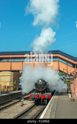 Motore a vapore lasciando Williton Stazione Ferroviaria sulla West Somerset Railway, Inghilterra nascosto dal vapore Foto Stock