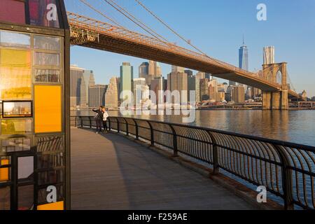 Stati Uniti, New York, Brooklyn Dumbo quartiere (Distretto sotto la Manhattan Bridge cavalcavia), coppia giovane Scattare foto nella parte anteriore del ponte di Brooklyn Bridge Foto Stock