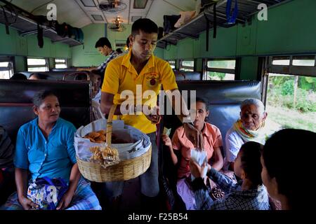 Sri Lanka, della provincia meridionale, in treno da Colombo a Galle, ciambelle venditore ambulante Foto Stock