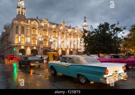 Cuba, Ciudad de la Habana Province, Centro Habana district, La Havana, vetture americane di fronte alla facciata illuminata del Gran Teatro de la Habana Foto Stock