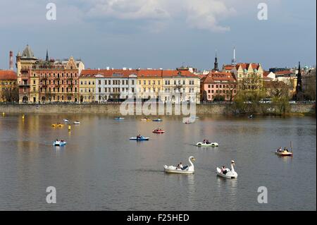 Repubblica Ceca, Praga centro storico sono classificati come patrimonio mondiale dall' UNESCO, barche a pedali sul fiume Moldava e le banche di Nove Mesto in background Foto Stock