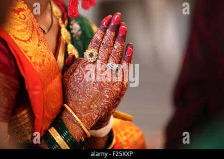 Cartella mani di un tradizionale indiano in sposa abiti da cerimonia, pregando durante il suo matrimonio. Foto Stock