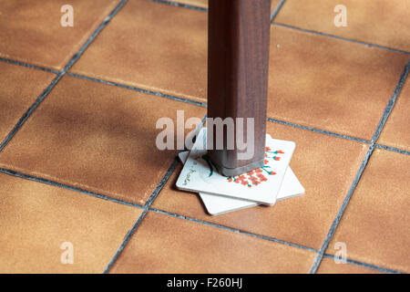 Gamba di un tavolo traballante supportato da montagne russe Foto Stock