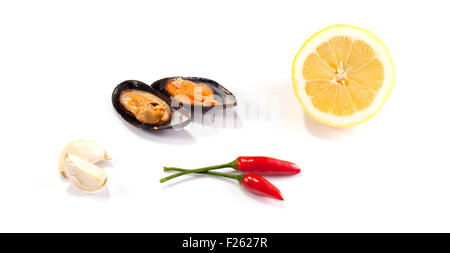 Cozze, limone e peperoncino su sfondo bianco Foto Stock