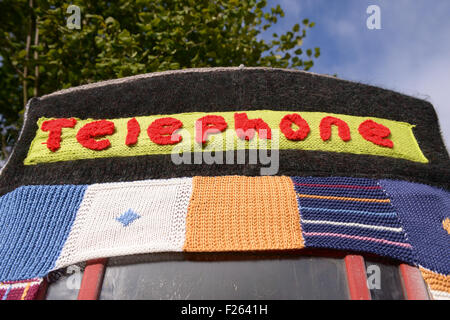 Kilsby, Northamptonshire, Regno Unito. 12 settembre 2015. Arredo urbano nel centro del villaggio sono state coperte con coperchi a maglia. Un segno accanto agli oggetti rende omaggio al Womens Institute 100 anni. Credito: Jamie grigio/Alamy Live News Foto Stock