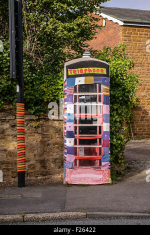 Kilsby, Northamptonshire, Regno Unito. 12 settembre 2015. Arredo urbano nel centro del villaggio sono state coperte con coperchi a maglia. Un segno accanto agli oggetti rende omaggio al Womens Institute 100 anni. Credito: Jamie grigio/Alamy Live News Foto Stock