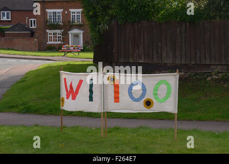 Kilsby, Northamptonshire, Regno Unito. 12 settembre 2015. Arredo urbano nel centro del villaggio sono state coperte con coperchi a maglia. Un segno accanto agli oggetti rende omaggio al Womens Institute 100 anni. Credito: Jamie grigio/Alamy Live News Foto Stock