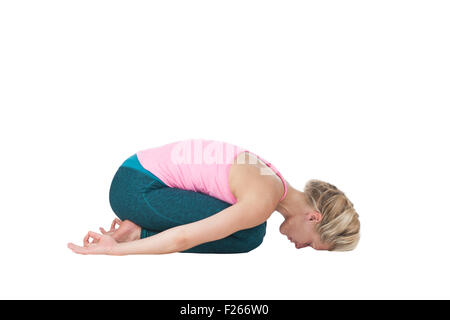 Yoga-serie immagine: lato corpo pieno in prospettiva di una donna bionda in posizione di yoga del bambino (Garbhasana) contro uno sfondo bianco Foto Stock