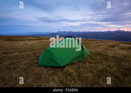 Una tenda si accamparono nel Mamores, Scozia, con i massicci montuosi di Glen Coe in background Foto Stock