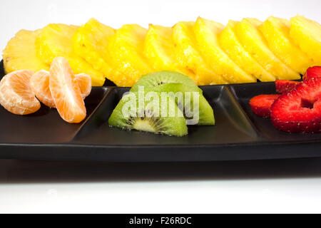 Frutta a fette su nero piattino Foto Stock